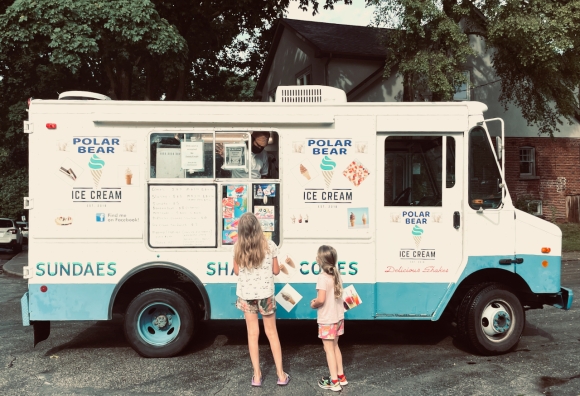 Photo of Lily and Beatrix deciding what to order from an ice cream truck in summer